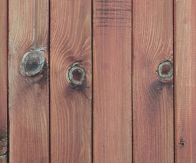 Close up of brown wooden fence panels. Many vertical wooden plan