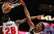 Porziņģa komandas biedrs Okongvu NBA dienas momentā paceļas gaisā un uzliek uz plakāta divus "Pistons" basketbolistus